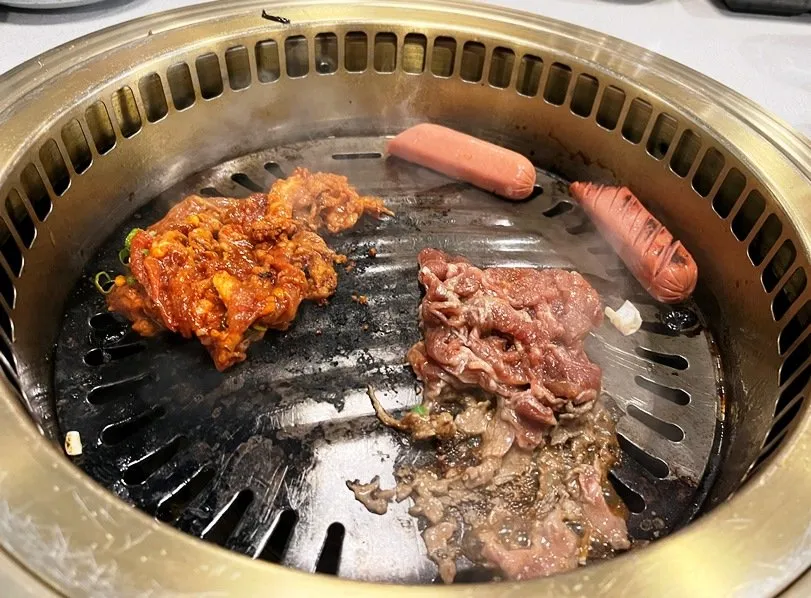 Spicy pork, sausage and marinated steak cooking at Seol Grille in Cary - nctriangledining.com